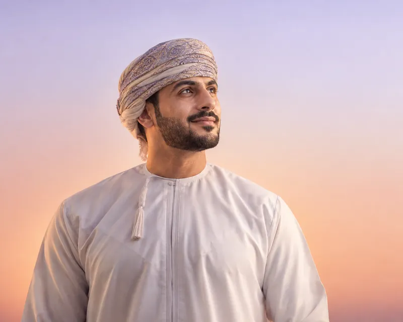 شاب عُماني يتطلع إلى الأفق في ضوء الغروب